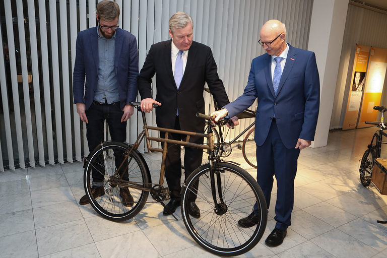 Wirtschaftsminister Althusmann (Mitte) und Kammerpräsident Steinmann (r.) bewundern eines der maßgeschneiderten Fahrräder von Kevin Höing (l.)