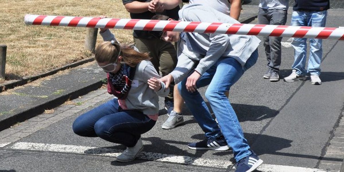 Die Azubi Paten mussten mit verbundenen Augen mit der Hilfe eines Partners unter einer Schranke hindurchgehen. Die Azubi Paten mussten mit verbundenen Augen mit der Hilfe eines Partners unter einer Schranke hindurchgehen.