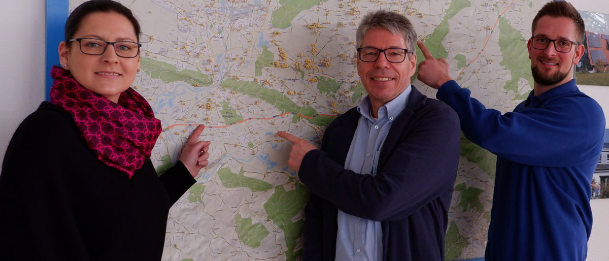 Viele Pins: Chef Dieter Ahrens (Mitte), Mitarbeiterin Nicole Krägenbring und Mitarbeiter Sascha Backhaus zeigen auf der Karte, wo Photovoltaikanlagen verbaut wurden. ahrens solar, photovoltaik, solaranlage, nachhaltigkeit