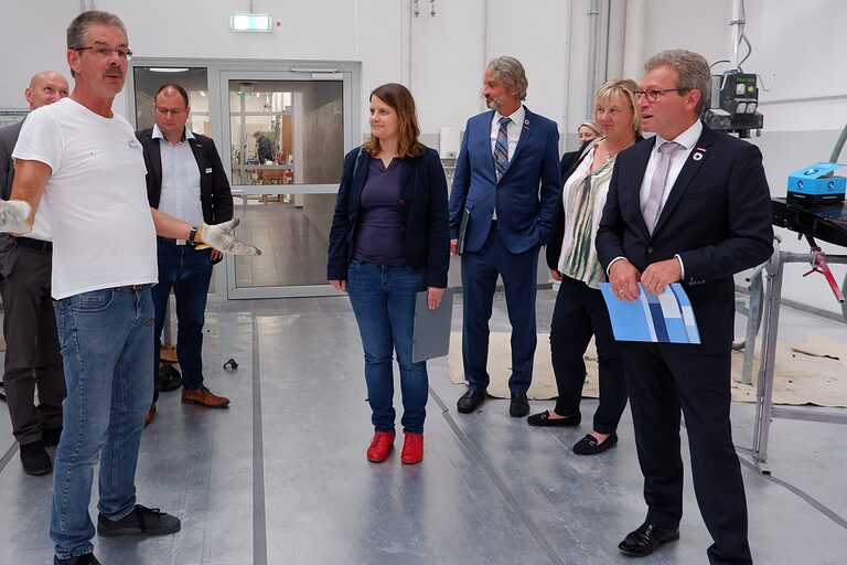 Ausbilder und Koordinator Holger Hartmann (l.) erläutert die modernen und frisch sanierten Werkstätten für die Fahrzeuglackierer. Ministerin Julia Hamburg beim Rundgang über den Campus Handwerk.