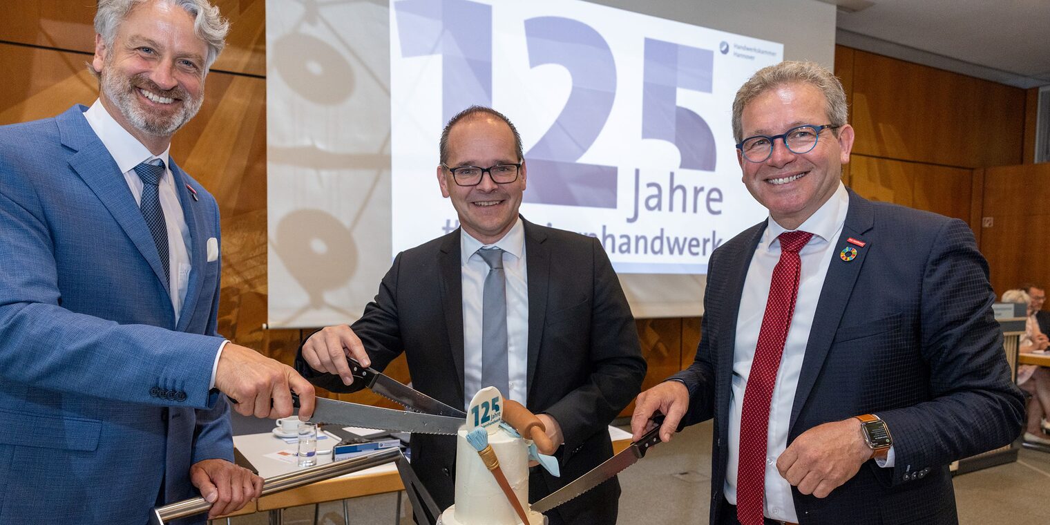 Peter Karst, Wirtschaftsminster Grant Hendrik Tonne und Kammerpräsident Thomas Gehre (v.l.n.r.) machen den Tortenanschnitt. 