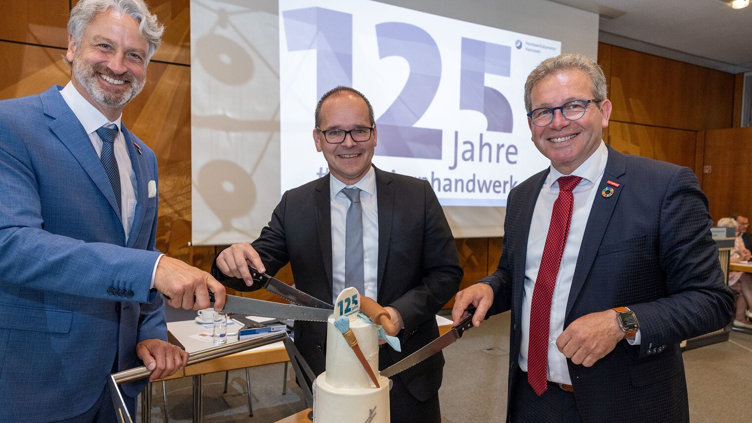 Peter Karst, Wirtschaftsminster Grant Hendrik Tonne und Kammerpräsident Thomas Gehre (v.l.n.r.) machen den Tortenanschnitt. 
