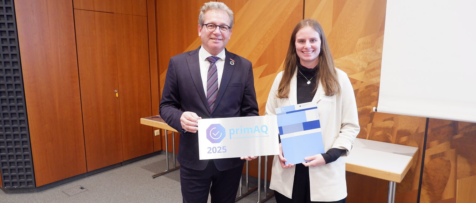 Eine Vertreterin der Funke GmbH & Co. KG nimmt die Auszeichnung vom Präsidenten der Handwerkskammer entgegen.