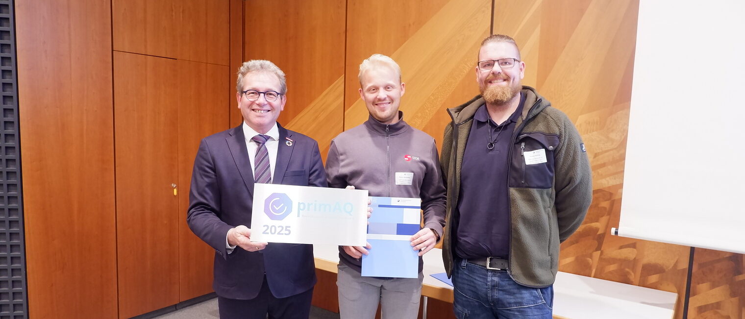 Robin Spremberg und Alexander Gaub nehmen die primAQ Auszeichnung von Thomas Gehre entgegen.