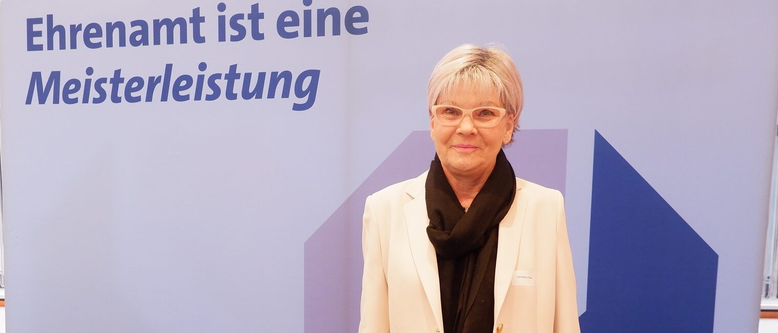 Constanze Huep steht vor einem Roll up Ehrenamt ist eine Meisterleistung.