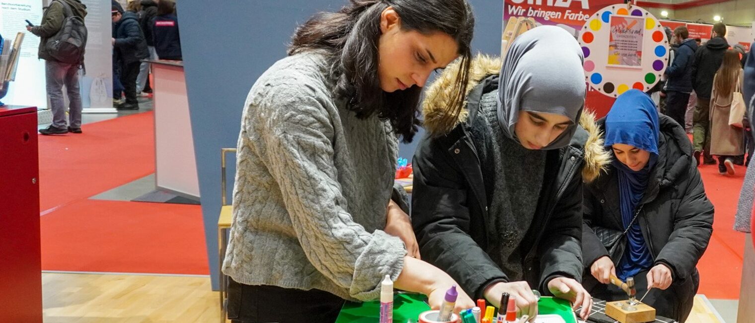Jugendliche testen ihr handwerkliches Geschick am Stand bei der Handwerkskammer Hannover beim Löffelschmieden.