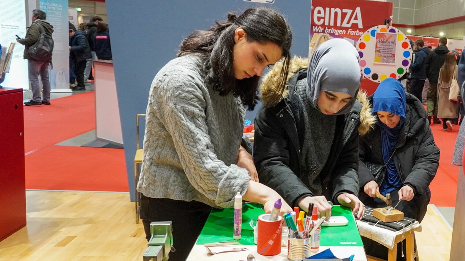 Jugendliche testen ihr handwerkliches Geschick am Stand bei der Handwerkskammer Hannover beim Löffelschmieden.
