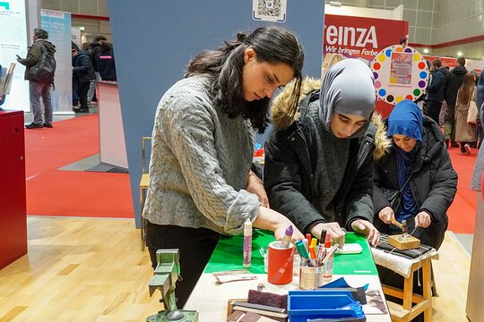 Jugendliche testen ihr handwerkliches Geschick am Stand bei der Handwerkskammer Hannover beim Löffelschmieden.