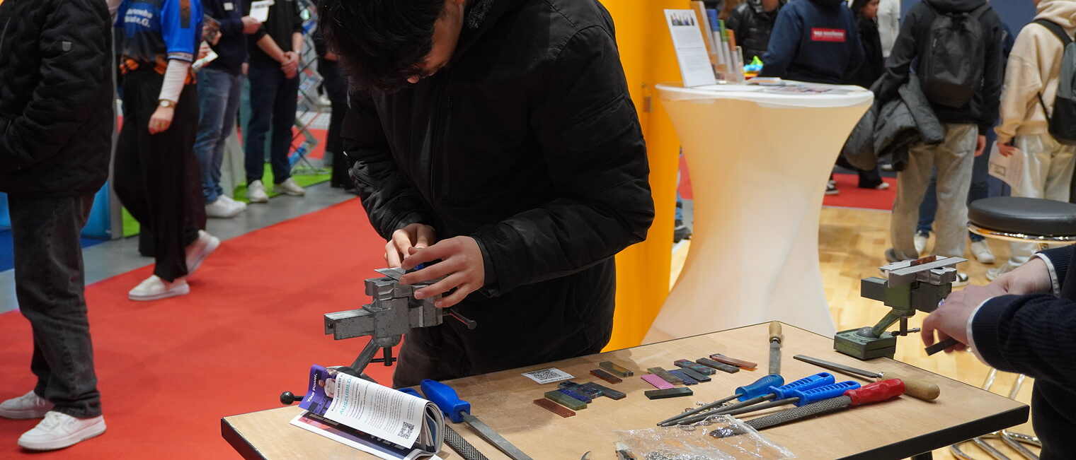 Jugendliche arbeitet an Maschine auf der Messe beruf & Bildung