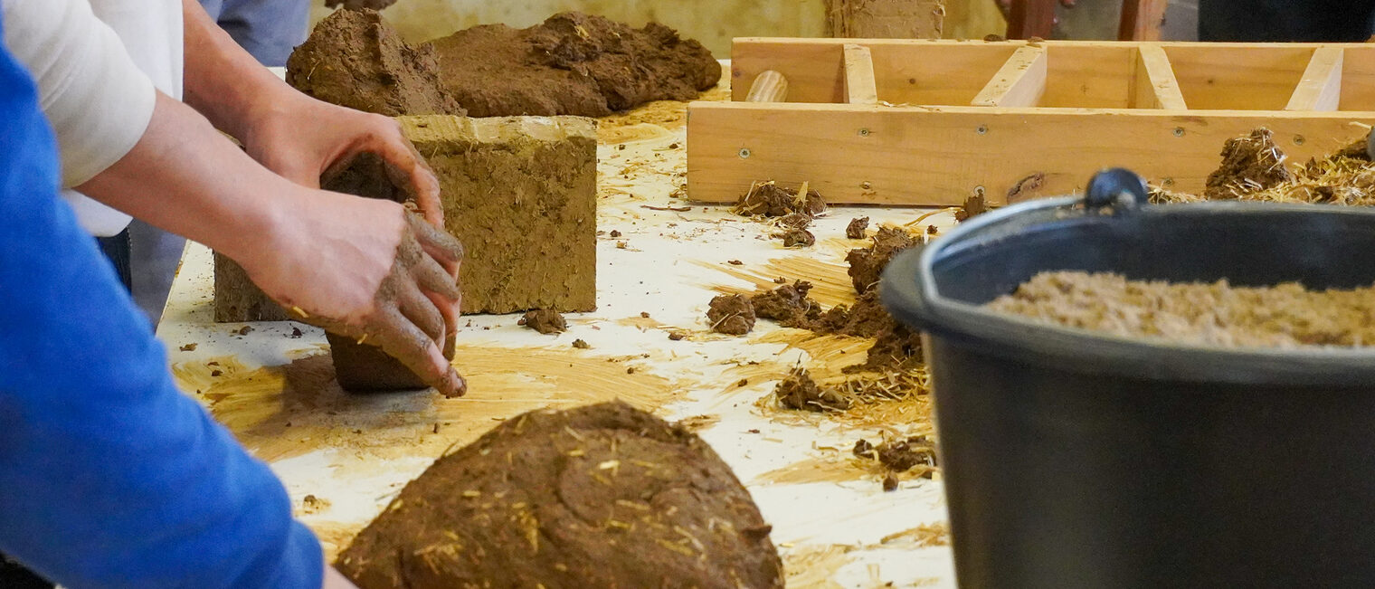 Detailaufnahme der Handgriffe im Lehmbau. 
