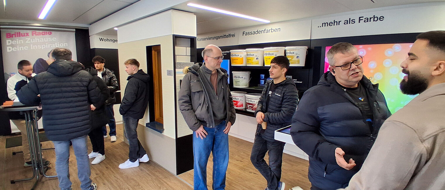 Besucher unterhalten sich im Brillux Show Truck.