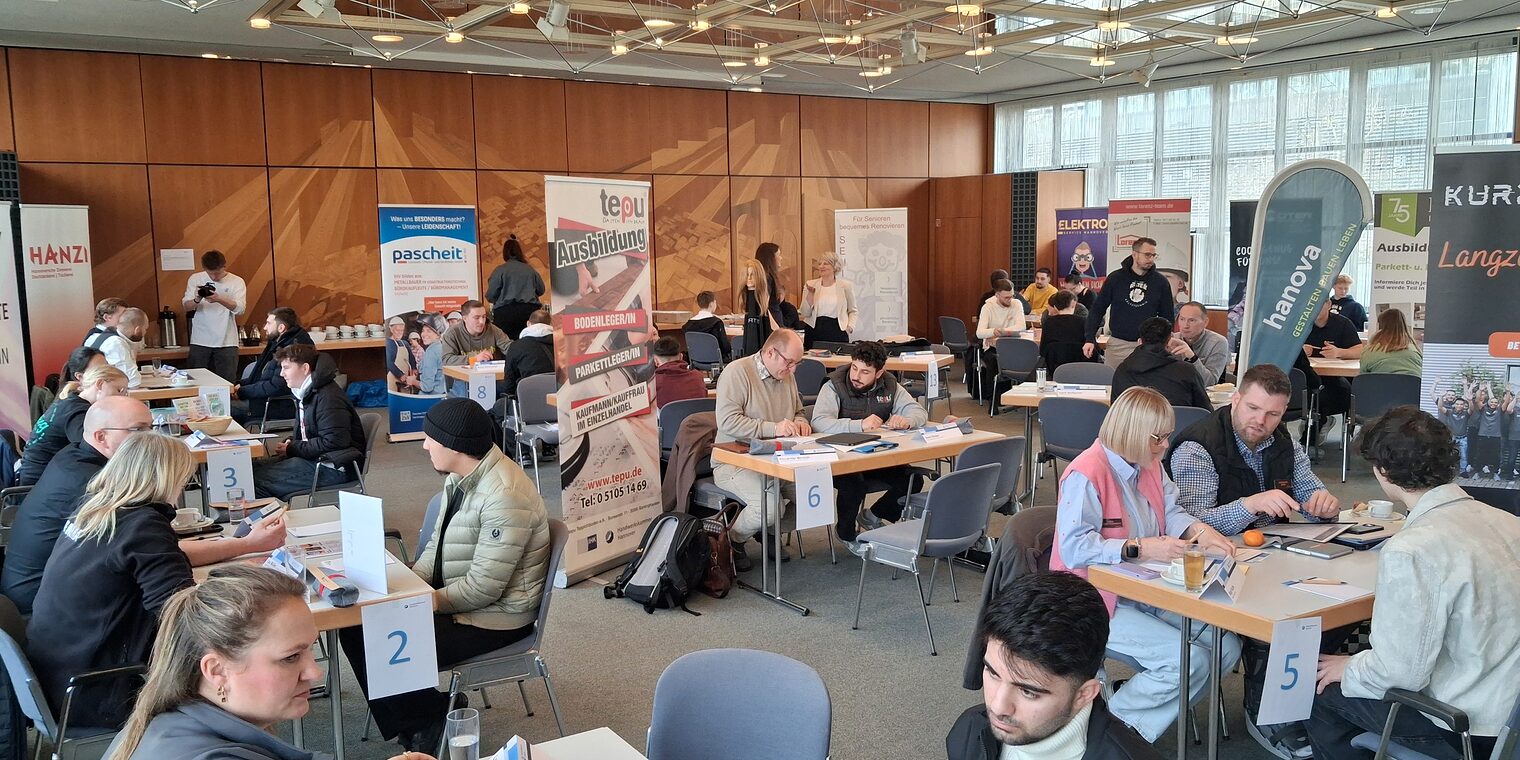 Jugendliche sitzen an vielen Tischen den Ausbildern der Handwerksbetriebe gegenüber.