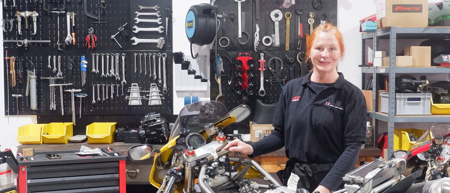 Eine Frau in einer Zweiradmechanikerwerkstatt.
