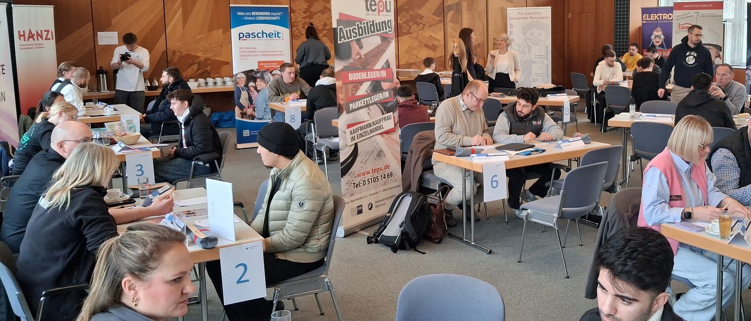 Menschen an Tischen beim Azubi Speed Dating