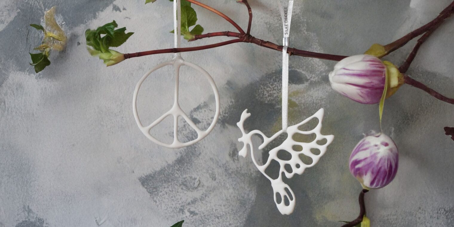 Anhänger aus Keramik: Peace-Zeichen und Taube an einem Ast.