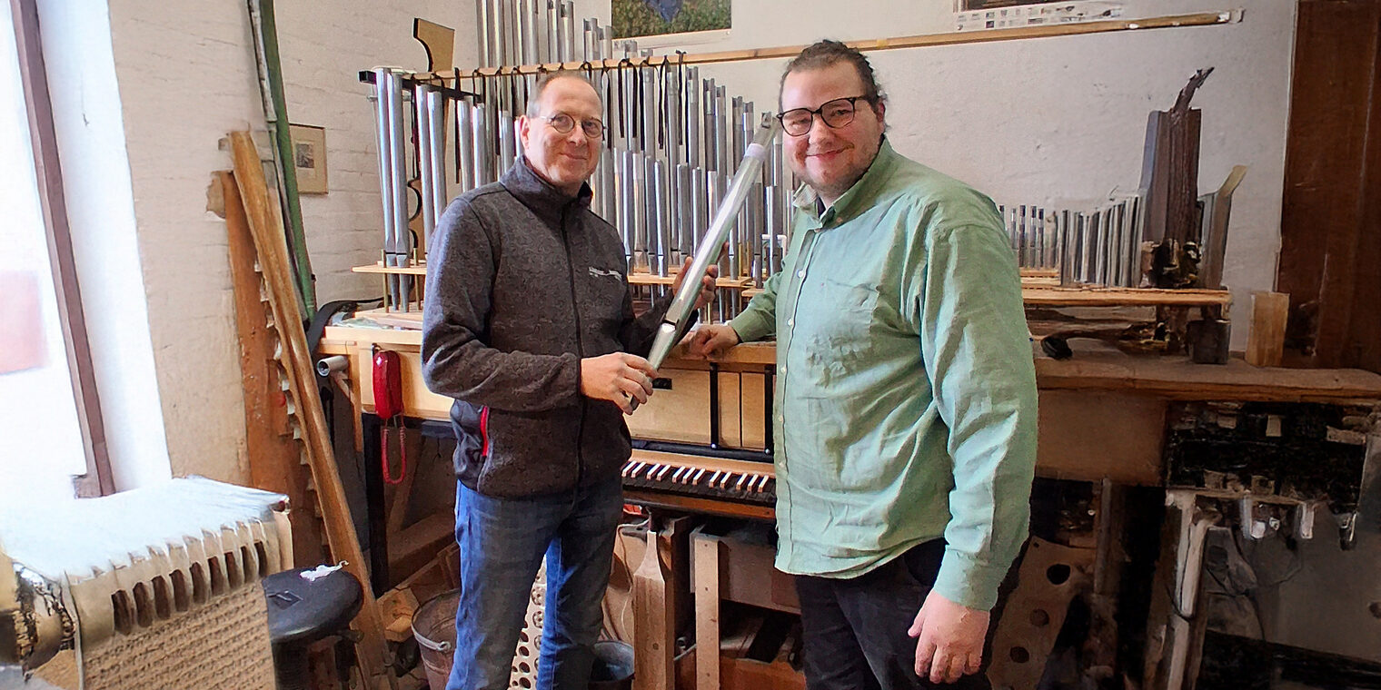 Orgelbauermeister Georg Schloetmann und Azubi Georg Blendermann inb der Werkstatt vor einer Orgel.