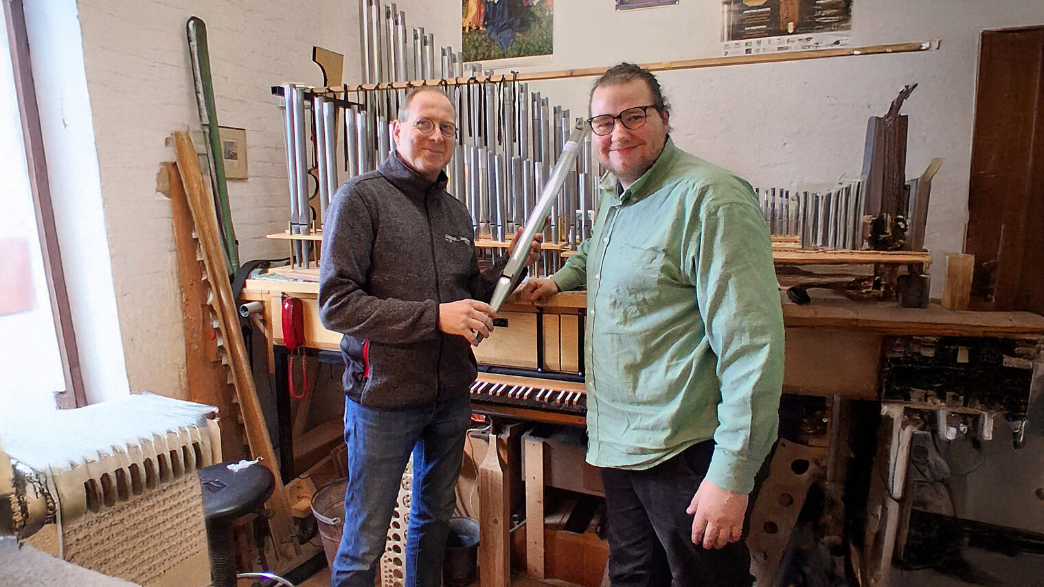 Orgelbauermeister Georg Schloetmann und Azubi Georg Blendermann inb der Werkstatt vor einer Orgel.
