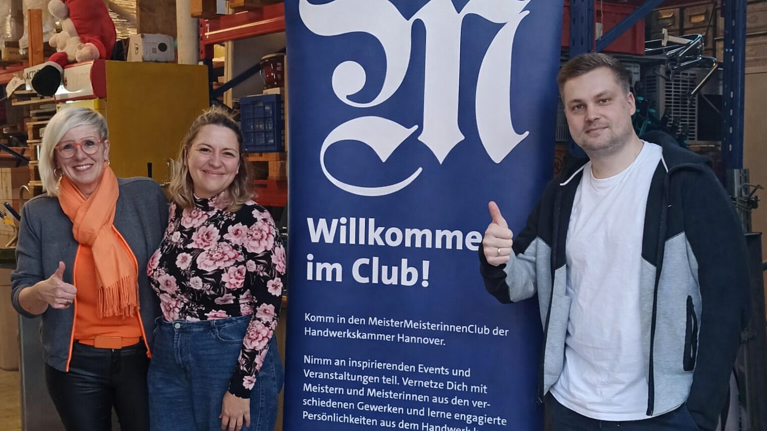 Die MMC-Koordinatoren Stephanie Fischer, Eva Tymko und Dennis Weiß vor einem MMC-Rollup.