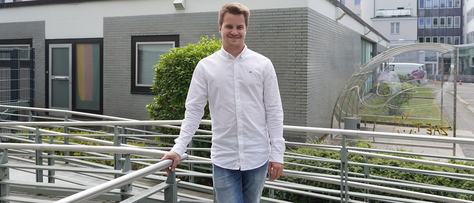 Marvin Sauer auf dem Außengelände der Handwerkskammer Hannover an der Treppe stehend.