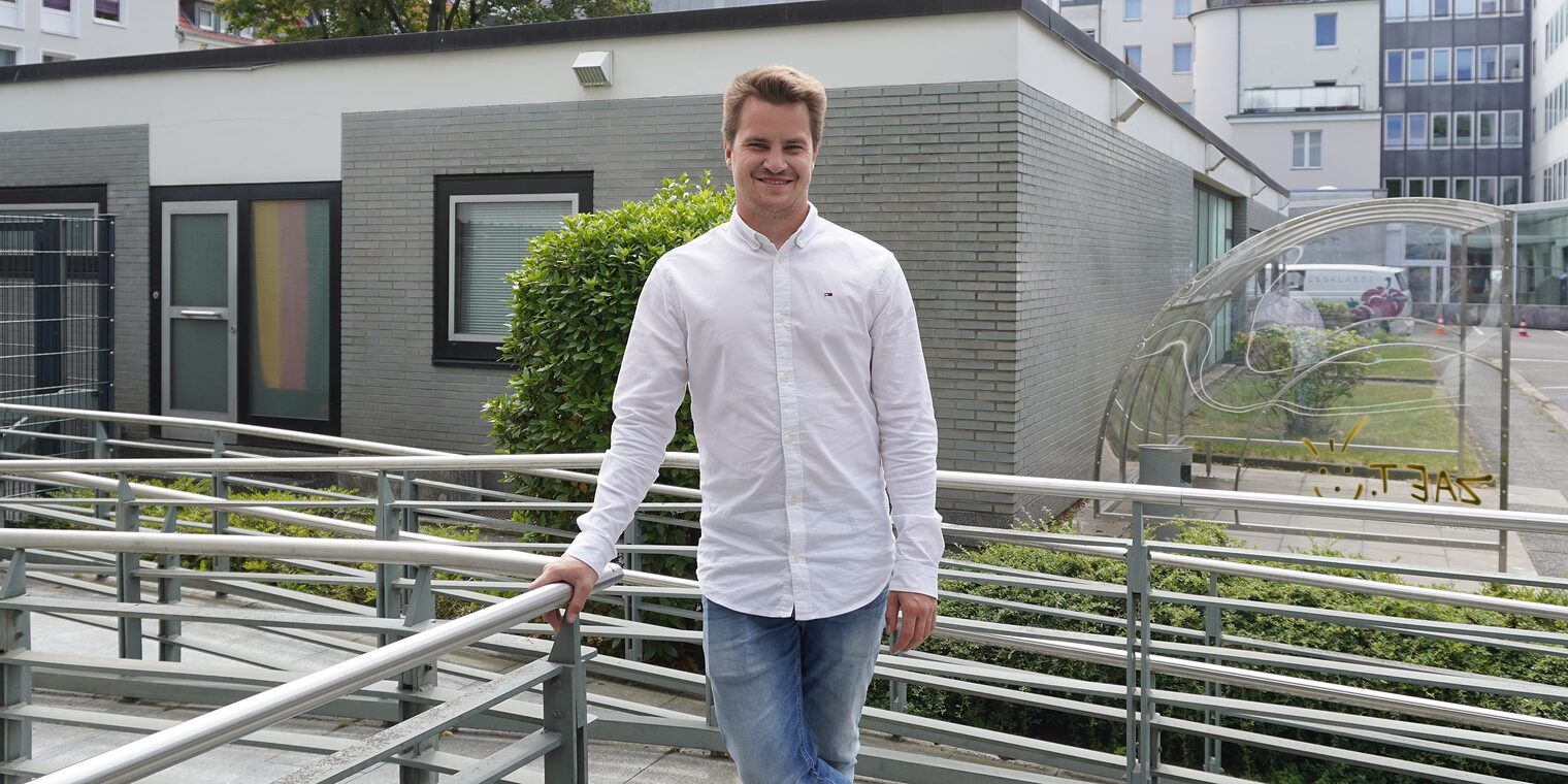 Marvin Sauer auf dem Außengelände der Handwerkskammer Hannover an der Treppe stehend.