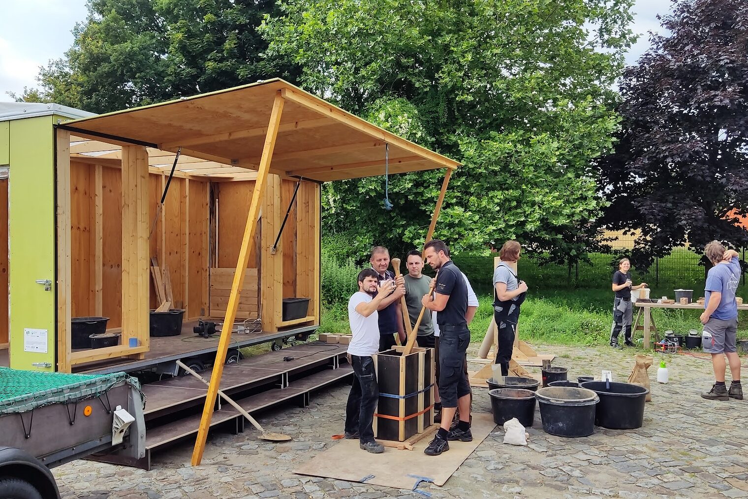 Menschen in der Gruppe auf einem außengelände, die sich Holz anschauen.