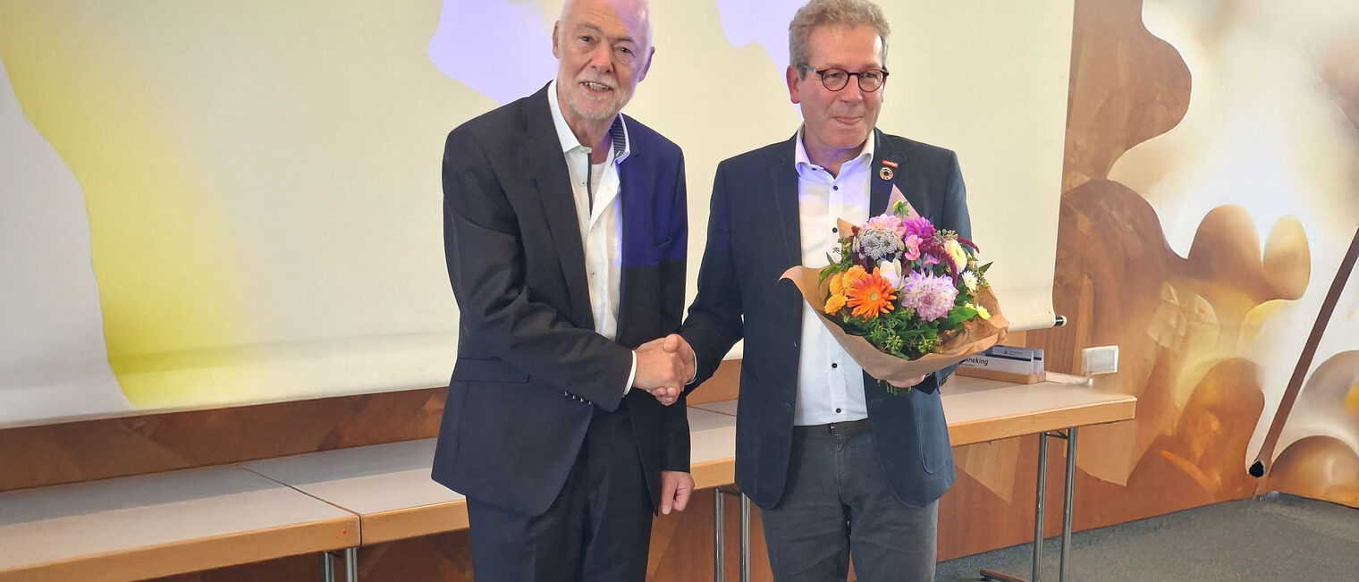 Thomas Gehre überreicht Herrn Wenzel einen Blumenstrauß.