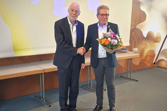 Thomas Gehre überreicht Herrn Wenzel einen Blumenstrauß.